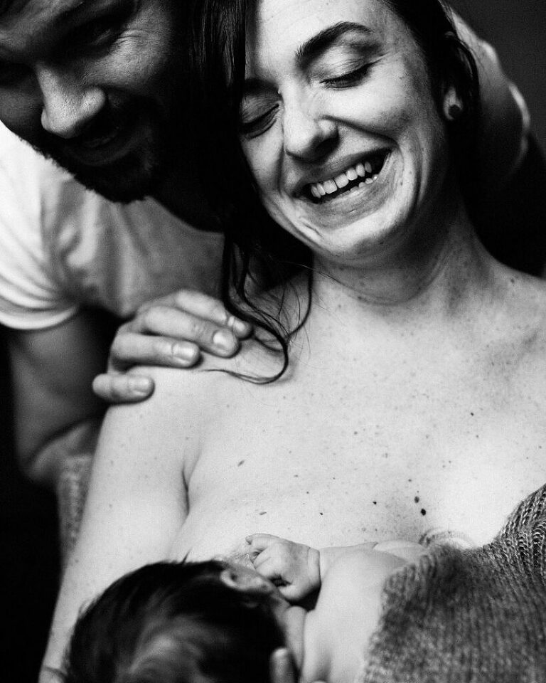 new parents laughing while breastfeeding